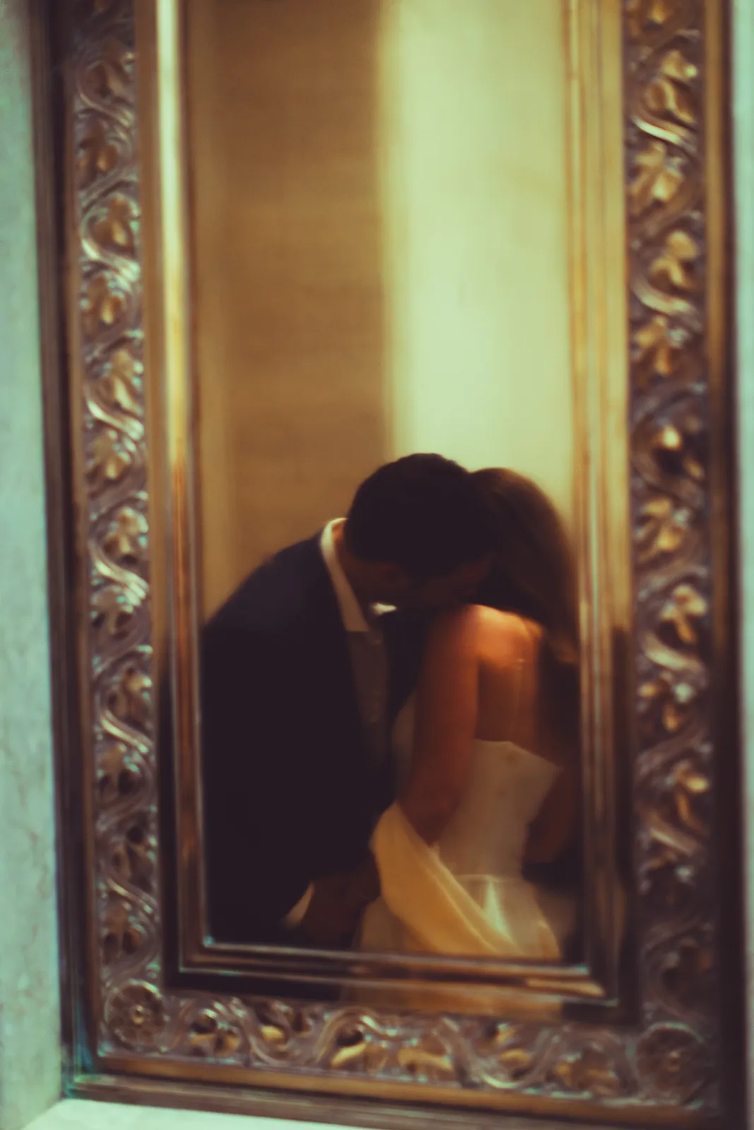 A kiss caught in an ornate brass mirror